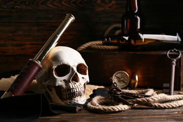 Skull with spyglass, keys and rope on wooden table. Pirate concept © Pixel-Shot