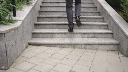 Modern businessman walking up the stairs in the city. Slow motion