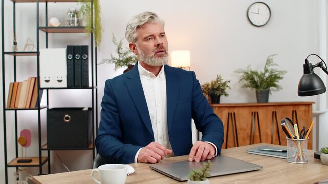 Middle-aged businessman at home office stares at laptop frozen error screen closes lid sighing again frustrated. Freelancer guy at table revises backup plan reallocating time to recover lost progress.