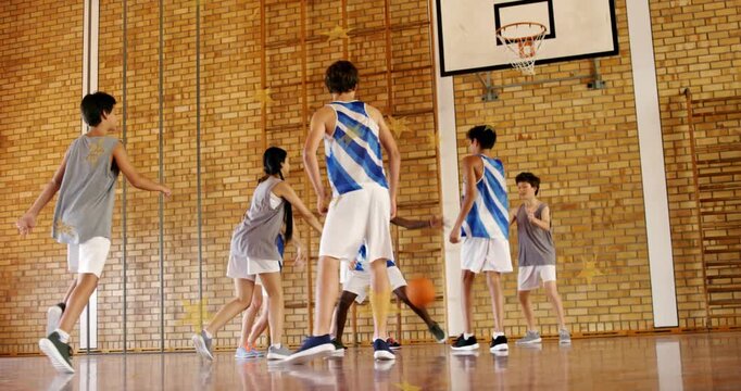 Players closing in school gym after ball landing at gray bib player's feet, contesting possession