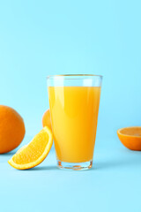Glass of fresh orange juice on blue background