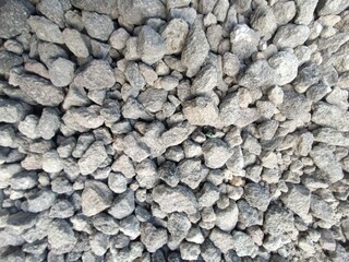 Close-up of natural gray granite rock surface texture with small, old lichen pattern