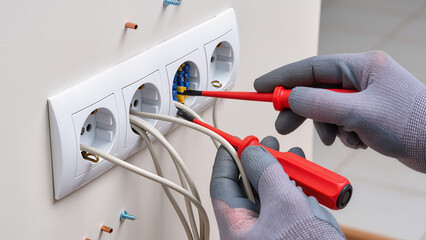 electrician installing electrical outlet