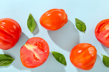 Fresh ripe tomatoes and basil on blue background