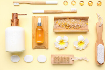Composition with different bath supplies, stones and plumeria on orange background