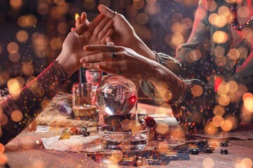 Fortune teller reading woman's palm at table