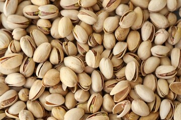 Tasty unpeeled pistachios as background, top view flat lay background