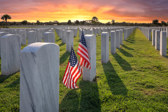Army veteran cemetery with white headstones and USA flag. Tombs of retired military soldiers. Memorial Day concept