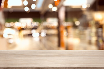Empty wooden table against blurred view of shopping mall. Space for design
