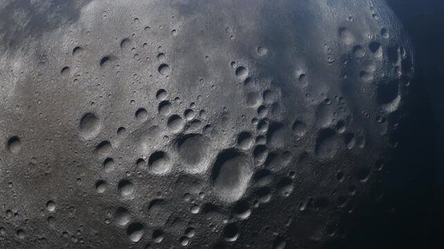 Detailed close-up view of the lunar surface showcasing numerous impact craters and a rugged, rocky texture against a dark space background.