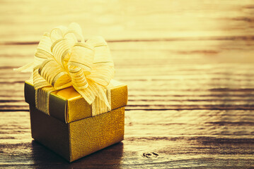 Golden ribbons  and Red color Christmas Gift Box white and golden lighting blur background