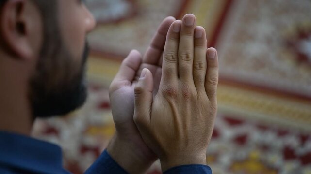 Reading the Quran. Ramadan & Eid content. A detail shot of a woman's hands holding an open Quran on a traditional wooden rehal (stand). Soft natural window light illuminates the pages.
