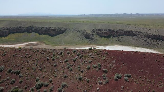 Tourists exploring the red surface of Lake Meke volcano crater rim in Konya