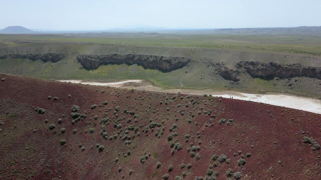 Tourists exploring the red surface of Lake Meke volcano crater rim in Konya