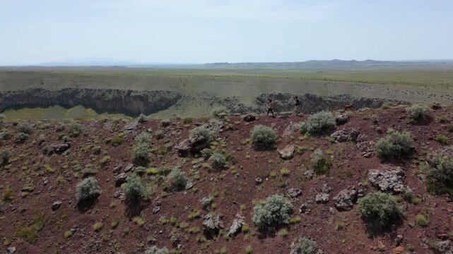 Tourists exploring the red surface of Lake Meke volcano crater rim in Konya