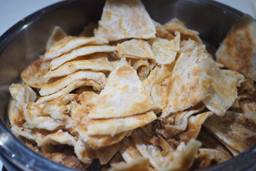 Piles of flatbread on a metal plate in a kitchen setting
