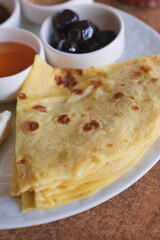 Tasty crepes served with syrups and olives for breakfast