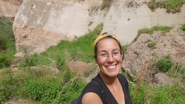 Young woman smiling and hiking in Soganli canyon in Cappadocia, Turkey