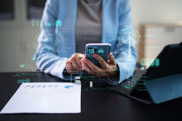 Fototapeta premium Woman using futuristic interface with smart tech and mobile to manage ESG, clean energy, and sustainability data.