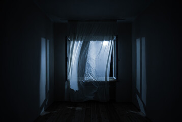 The wind from the window flutters the curtains in the old house in the moonlight.