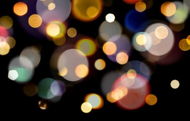 Colorful blurred Bokeh lights on black background used for overlay. Rainbow pastel Bokeh lights multicolour. Abstract glowing dynamic sparks or Bokeh lights background.