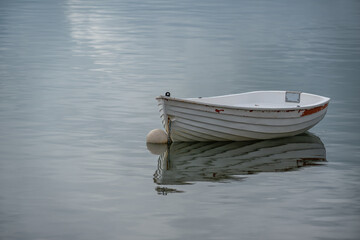 White dingy reflected on a glassy sea - white on white