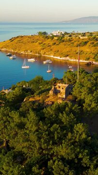 Vertical video. Bodrum, Turkey. Morning aerial drone view of the ancient Tiger Tower on a forested hill. This 4th century BC watchtower was built under King Mausolos as part of Halicarnassus defense 