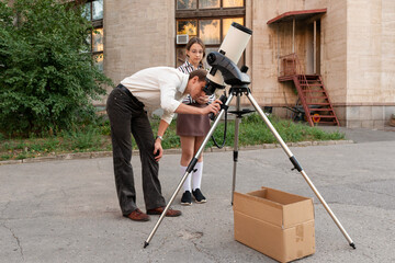 Man demonstrates telescope alignment to a young student during an astronomy lesson outdoors, ensuring proper adjustment for upcoming celestial observations