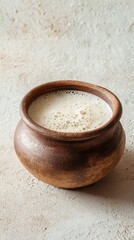 Emasi fermented milk in a clay pot with gentle froth, dish from Eswatini on ivory background, minimalist food photo, template for social media, digital ad, web banners, mobile wallpaper, greeting card