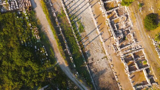 Gelemis, Turkey. Colonnaded Street and Agora archaeological complex in Patara, ancient urban structures in morning light. Aerial View, HEAD OVER SHOT with rotation, MasterShots