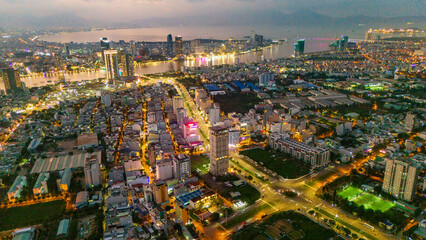 Aerial drone panorama of Da Nang city center split by the Han River. Massive urban skyline featuring iconic bridges connecting the modern metropolis in Vietnam