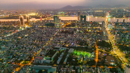 Aerial drone panorama of Da Nang city center split by the Han River. Massive urban skyline featuring iconic bridges connecting the modern metropolis in Vietnam