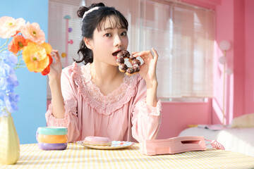 カラフルな部屋でドーナツを食べるかわいい女性のポートレート