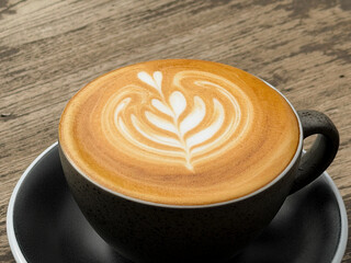 Hot coffee, a hot latte in a mug on a wooden table.