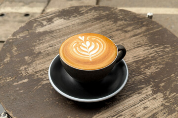 Hot coffee, a hot latte in a mug on a wooden table.