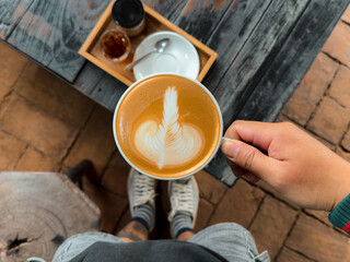 Hot coffee. Holding a hot latte in a mug from the cafe.