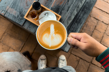 Hot coffee. Holding a hot latte in a mug from the cafe.