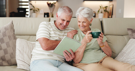 Coffee, laughing and tablet with old couple on sofa in living room of home together for break. Bonding, funny and streaming app with happy senior people drinking beverage in apartment for wellness