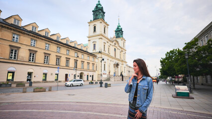 Obraz premium Young tourist woman smiling in front of historic church