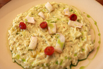 Creamy orzo pasta dish with grilled squid and roasted cherry tomato