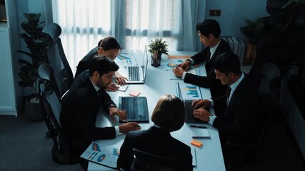 Top view of business people working together to analysis stock market data while sitting at meeting table with financial statistic graph. Project manager planning strategy by using laptop. Directorate - Powered by Adobe