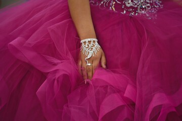  Formal magenta color Quinceañera gown, embroidered with rhinestones and sequins worn by a young...