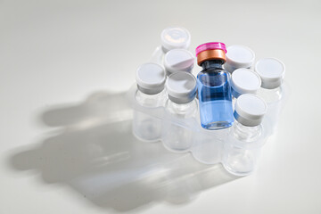 Close up of Glass Vials with Lyophilized Substance Inside with One reconstituted Vial with Copper Peptides