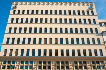 Symmetrical Modern Apartment Building Facade with Grid Windows Against Clear Blue Sky