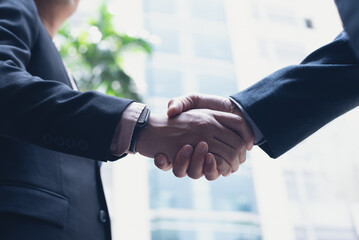Businessmen making handshake in the city,  business etiquette, congratulation, merger and...