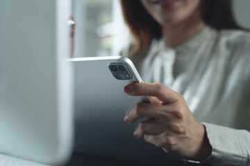 Closeup, Business woman using digital tablet and working on laptop computer at office. Woman hand holding tablet pc, online working, internet networking, corporate business, remote work