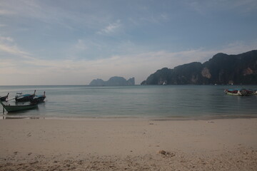 View of Tonsai bay with longtail boats and  rocks during sunset in Phi Phi island,  Phuket, Krabi province , Thailand. 