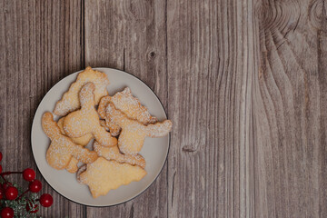 A plate of homemade biscuits on a wooden table. Rustic style, cozy atmosphere and mouth-watering pastries are the perfect frame for culinary holiday projects.