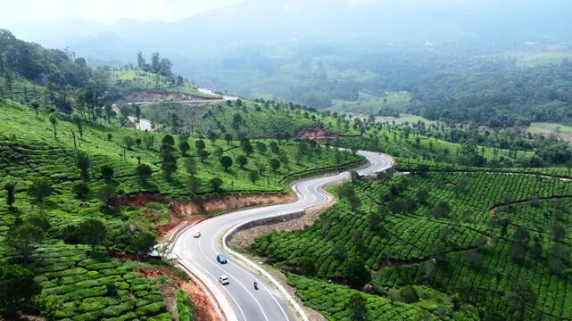 Drone shot of green hills and road in Munnar landscape
