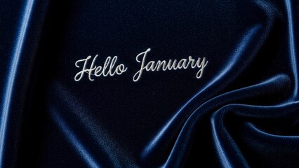 Hello January text on dark blue fabric with subtle light reflections.